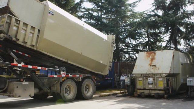 Recycling Truck loading into and dropping off recycled waste at recycling waste management center