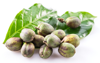 Green coffee beans and fresh coffee leaves on white background.