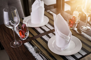 Reserved sign on a table in restaurant. Empty glasses set in restaurant