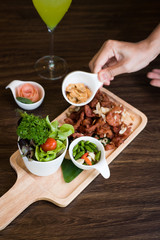 Fried Pork with Garlic. Deep Fried Crispy Pork Belly Cooked with Garlic and spicy dipping sauce on wooden table background
