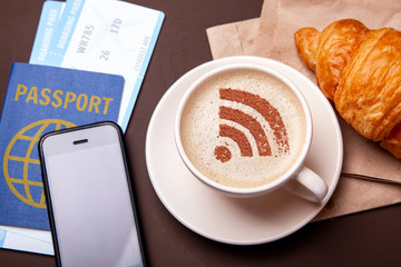 Mug of coffee with WiFi sign on the foam. Free access point to the Internet WiFi. I like coffee break with croissant