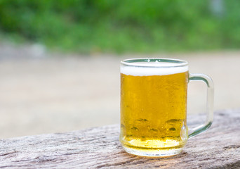 Glass of beer on wooden table.