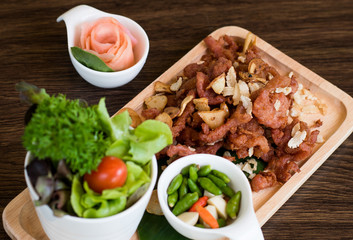 Fried Pork with Garlic. Deep Fried Crispy Pork Belly Cooked with Garlic and spicy dipping sauce on wooden table background