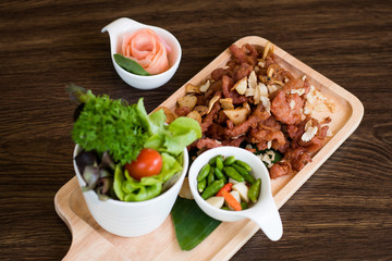 Fried Pork with Garlic. Deep Fried Crispy Pork Belly Cooked with Garlic and spicy dipping sauce on wooden table background