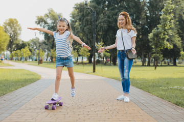 Wrist watch. Little cute girl wearing white wrist watch feeling free and unbelievable while riding skateboard