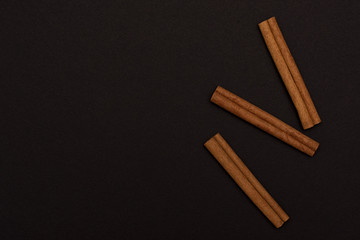 cinnamon sticks on black background top view with copy space for text