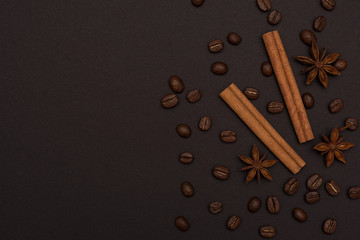 cinnamon sticks, cardamom and coffee beans on a black background top view with copy space for text