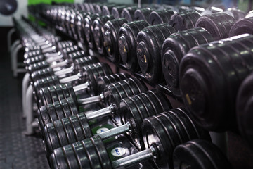 Black dumbbell set in sport fitness center. Weight Training Equipment concept.