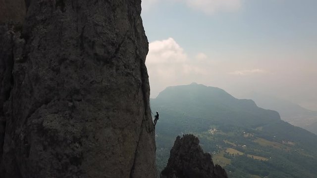 drone view of two person climbing a rock