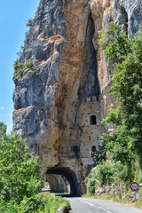 The castle carved into the rock/In the rock above the river, a medieval castle was cut out. Now the road passes under it
I