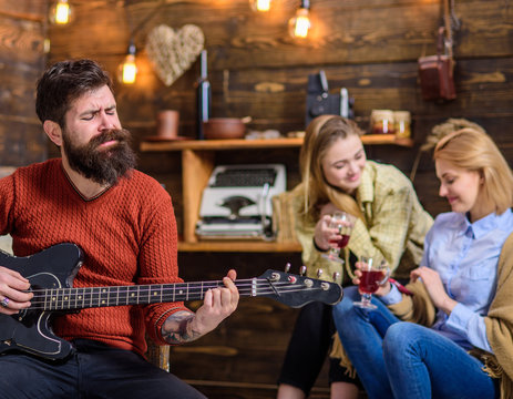 Musician putting all heart into his art. Bearded man singing passionately love song. Girls enjoying touching performance of bearded guitarist. Hipster with bushy beard playing electronic guitar