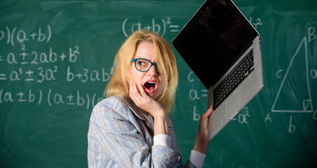 Teacher woman raising laptop above herself ready to destroy. Working conditions of teachers causes...