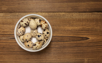 Obraz na płótnie Canvas background. chicken and quail eggs in a white bowl on a wooden table
