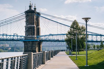 Walkway and the John A. Roebling Suspension Bridge, seen at Smale Riverfront Park, in Cincinnati, Ohio.