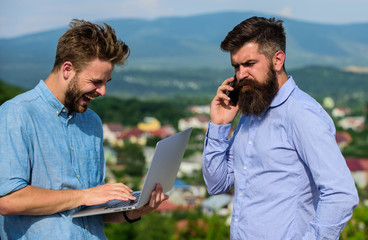 Colleagues with laptop work outdoor sunny day nature background. Business partners in formal wear...