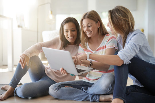 Friends sharing home, connected with laptop