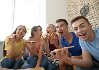 Young people taking selfie with delicious pizza at home party