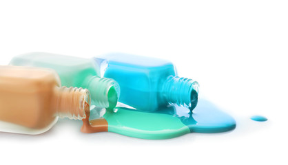 Open bottles of nail polishes on white background