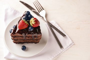 Piece of delicious chocolate cake with berries on plate