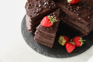 Fototapeta na wymiar Delicious chocolate cake with strawberry on slate plate