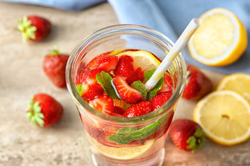 Natural lemonade with strawberries in glass on table