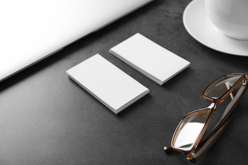 Blank business cards with eyeglasses on grey table