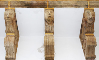 Details of a balcony with ancient anthropomorphic figures. Gallipoli, Salento, Puglia – Apulia, Italy