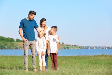 Happy family near river on summer day