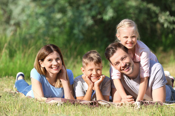 Fototapeta premium Happy family resting in park on summer day