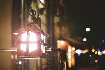 old forged metal kerosene lantern on background night street