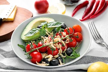 Plate with tasty salad on table