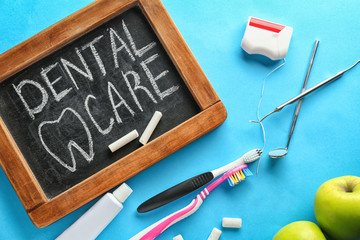 Composition with blackboard and dental hygiene equipment on color background. Healthy teeth concept © Pixel-Shot