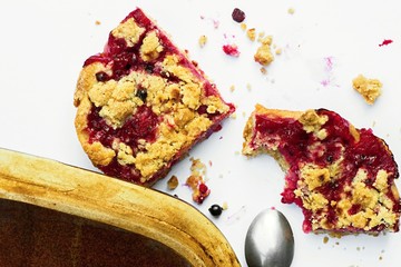 Red currant cake, spoon and pan on dirty white background.