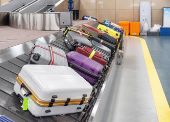 Suitcases on luggage conveyor belt at arrival area of airport