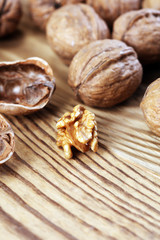 Walnut kernels and whole walnuts on rustic old table.