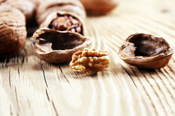 Walnut kernels and whole walnuts on rustic old table.