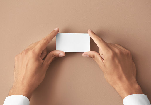 Man with business card on color background, closeup - Powered by Adobe