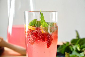 Glass of tasty strawberry lemonade on blurred background, closeup