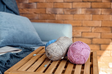 Colorful knitting yarn on wooden crate in room