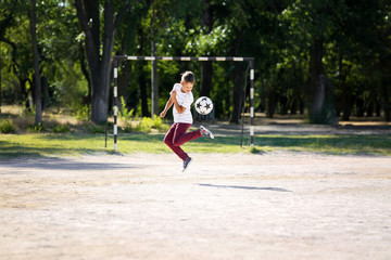 Little boy playing football on soccer pitch © Pixel-Shot