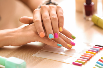 Obraz na płótnie Canvas Young woman with colorful manicure in beauty salon
