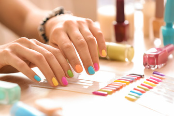 Young woman with colorful manicure in beauty salon
