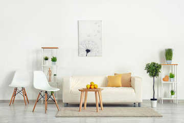 Stylish furniture with comfortable sofa near light wall