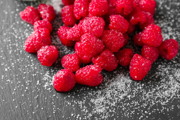 Delicious fresh ripe raspberries with sugar on slate plate