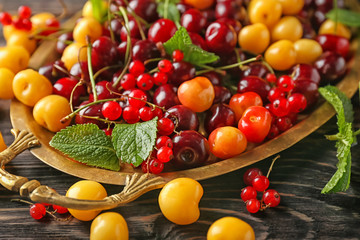 Tray with ripe berries on wooden table