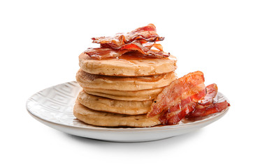 Tasty pancakes with fried bacon on white background