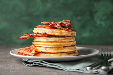 Tasty pancakes with fried bacon on plate