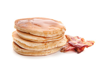 Tasty pancakes with fried bacon on white background