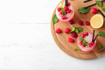 Glasses of fresh raspberry mojito on wooden board
