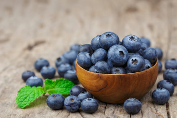 Blueberries in a wood bowl on a wooden table, Healthy eating and nutrition concept